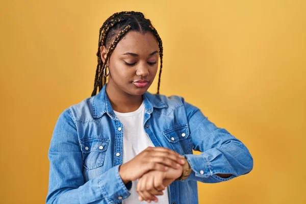 Африканская Американка Косичками Стоящая Желтом Фоне Проверяя Время Наручных Часах — стоковое фото