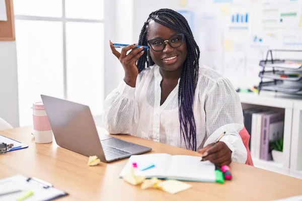 アフリカ系アメリカ人の女性ビジネスワーカーがオフィスでノートパソコンで音声メッセージを聞く — ストック写真