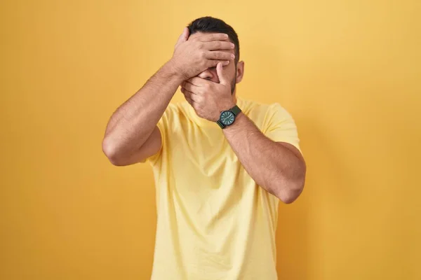 Young Hispanic Man Standing Yellow Background Covering Eyes Mouth Hands — ストック写真