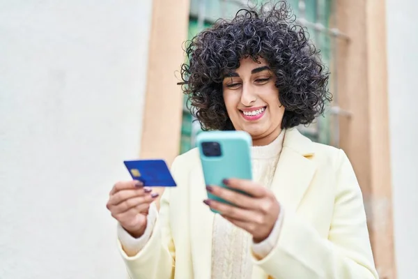 年轻的中东女性高管在街上使用智能手机和信用卡 — 图库照片