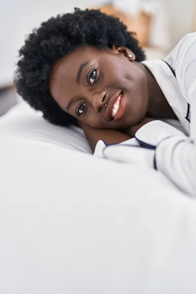年轻的非洲女人笑着自信地躺在床上 躺在卧室里 — 图库照片