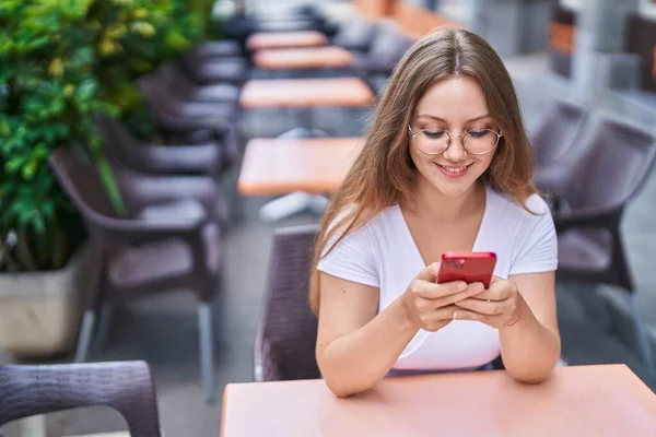 Junge Blonde Frau Sitzt Mit Smartphone Auf Kaffeeterrasse Tisch — Stockfoto