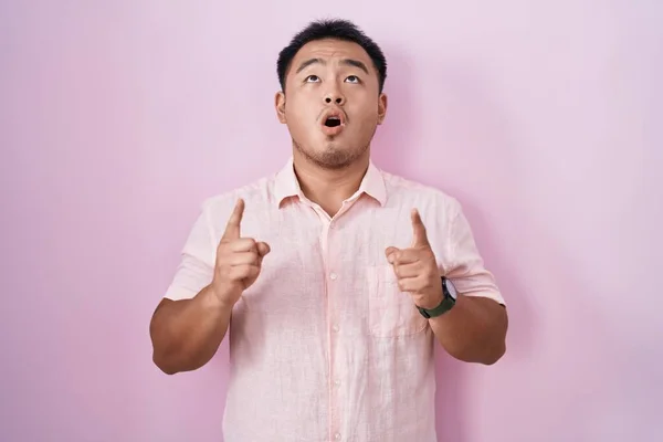 Chinese Young Man Standing Pink Background Amazed Surprised Looking Pointing — Stock Photo, Image