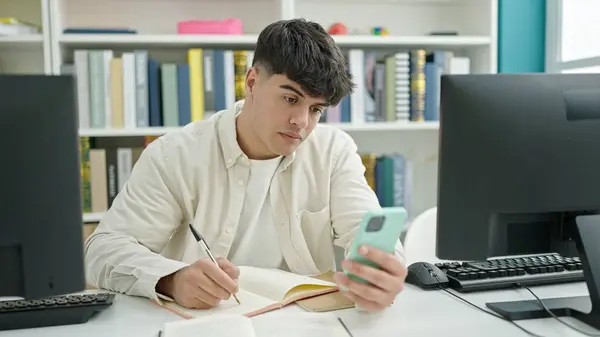 Junger Hispanischer Student Schreibt Mit Smartphone Notizen Bibliothek — Stockfoto
