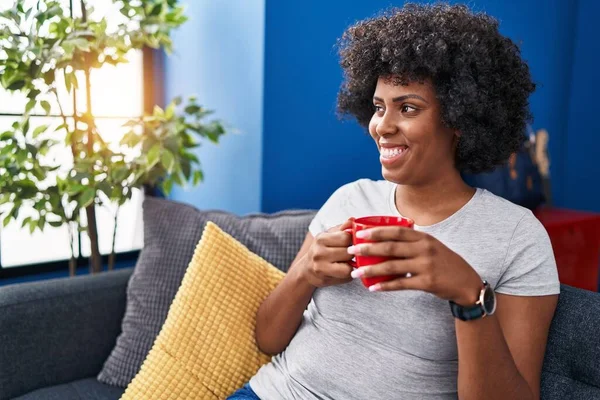 African American Woman Drinking Coffee Sitting Sofa Home — стокове фото