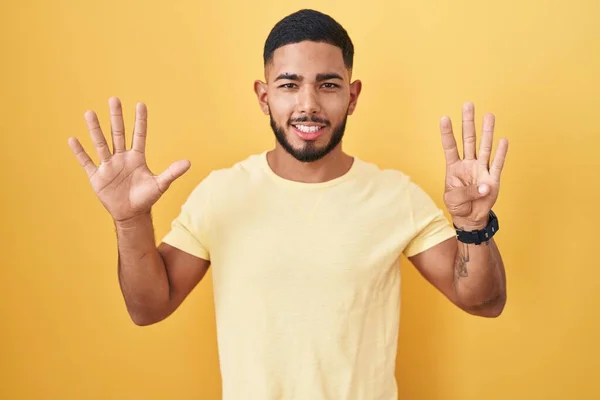 Молодий Іспаномовний Чоловік Стоїть Над Жовтим Тлом Показуючи Вказуючи Пальцями — стокове фото