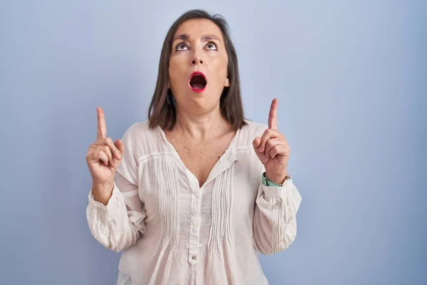 Middle Age Hispanic Woman Standing Blue Background Amazed Surprised Looking — Foto Stock