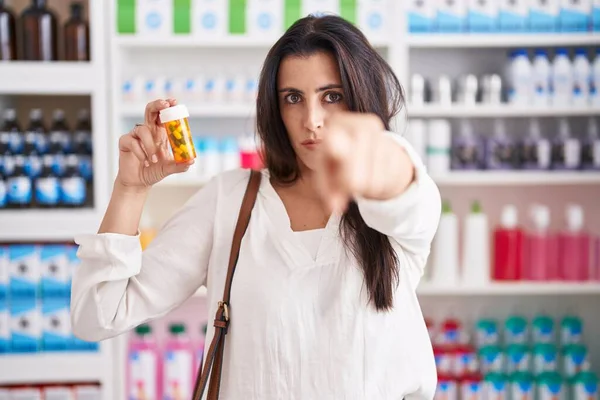 Молодая Брюнетка Женщина Покупки Аптеке Держа Таблетки Указывая Пальцем Камеру — стоковое фото