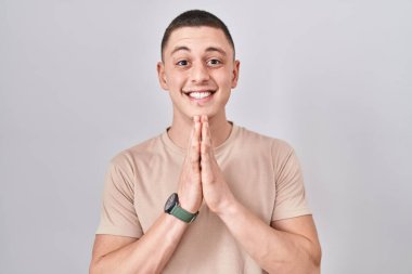 İzole edilmiş arka planda duran genç adam birlikte dua ederek af diliyor kendinden emin bir şekilde gülümseyerek.. 