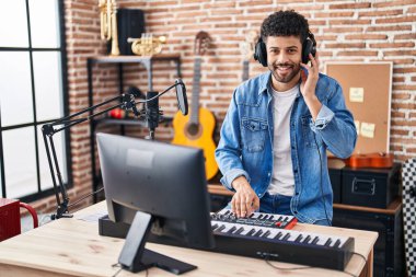 Genç Arap müzisyen müzik stüdyosunda piyano klavyesi çalıyor.