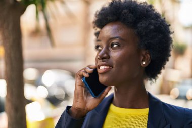 Young african american woman business executive talking on the smartphone at street