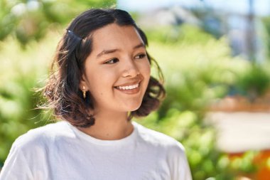 Young woman smiling confident looking to the side at park