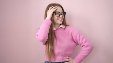 Young blonde woman smiling confident standing over isolated pink background