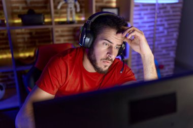 İspanyol asıllı genç adam oyun odasında bilgisayar kullanarak strese girdi.