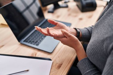 Young beautiful hispanic woman ecommerce business worker suffering for wrist pain at office