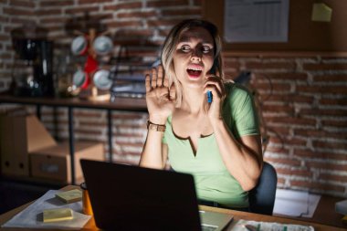 Geceleri ofiste çalışan genç ve güzel bir kadın telefonda konuşurken kulağından kulaklarına gülümseyerek dedikoduları ve dedikoduları dinliyor. Sağırlık kavramı. 