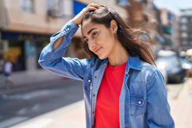 Young hispanic girl smiling confident looking to the side at street