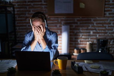 Geceleri ofiste çalışan güzel esmer kadın. Ağlarken yüzünü ellerle kapatan üzgün bir yüz ifadesi. depresyon kavramı. 