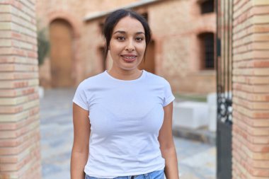 Young arab woman smiling confident at street