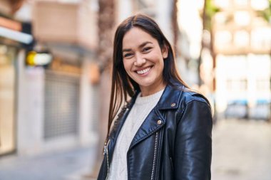 Sokakta kendinden emin gülümseyen genç bir kadın