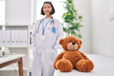 Klinikte doktor üniforması giyen genç bir kadın.