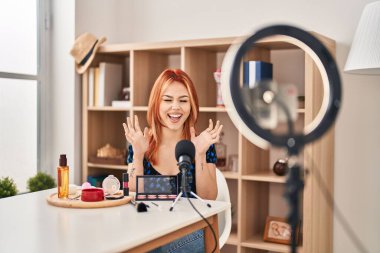 Makyaj yapmak için makyaj yapan beyaz bir kadın kollarını kaldırmış ve gözleri kapalı heyecanla haykırarak başarı için deli ve çılgın bir kutlama yapıyor. Kazanan konsept 