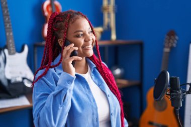 African american woman artist talking on smartphone at music studio