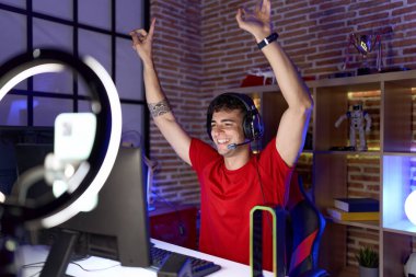 Oyun odasında İspanyol asıllı genç adam video oyunu oynuyor.