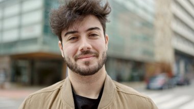 Sokakta kendinden emin gülümseyen İspanyol genç adam.