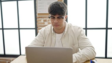 Young hispanic man business worker using laptop working at office