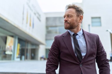 Middle age man business worker standing with serious expression at street