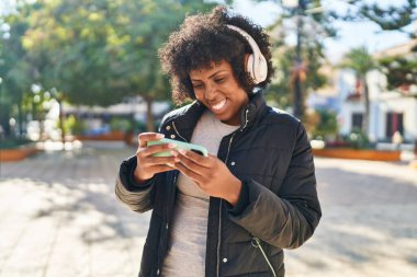 Afro-Amerikalı kadın, parkta oynarken kendine güvenen gülümsüyor.