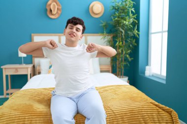 Non binary man waking up stretching arms at bedroom