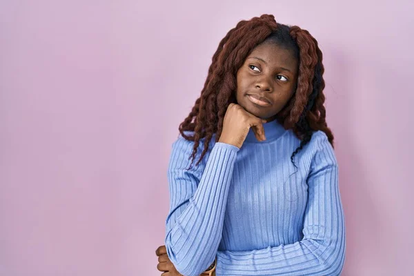Mujer Africana Pie Sobre Fondo Rosa Con Mano Barbilla Pensando —  Fotos de Stock