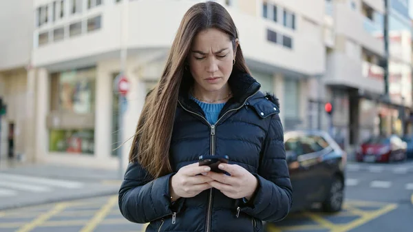 Młoda Kaukaska Kobieta Pomocą Smartfona Patrząc Zdenerwowany Ulicy — Zdjęcie stockowe