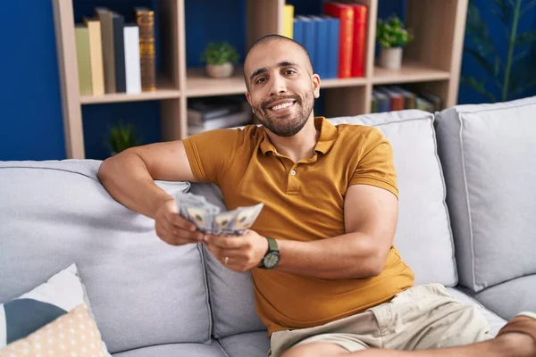 Young Latin Man Counting Dollars Sitting Sofa Home — 图库照片