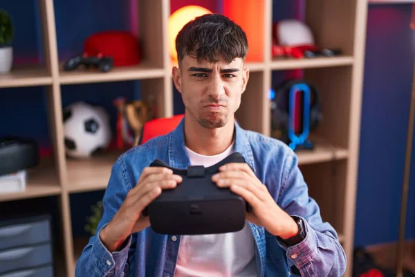 Junger Hispanischer Mann Mit Virtual Reality Brille Skeptisch Und Nervös — Stockfoto