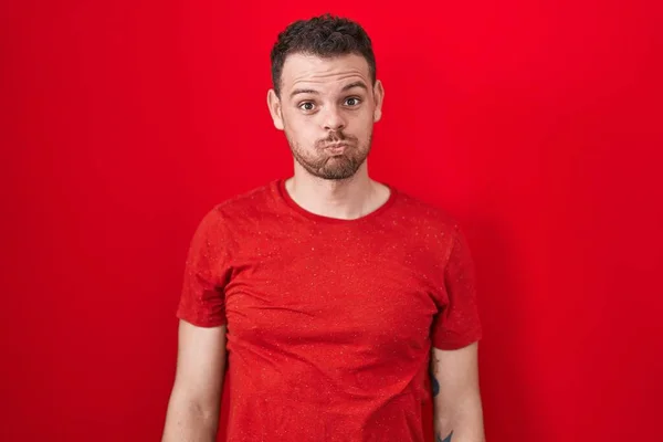 Young Hispanic Man Standing Red Background Puffing Cheeks Funny Face — Stock Photo, Image