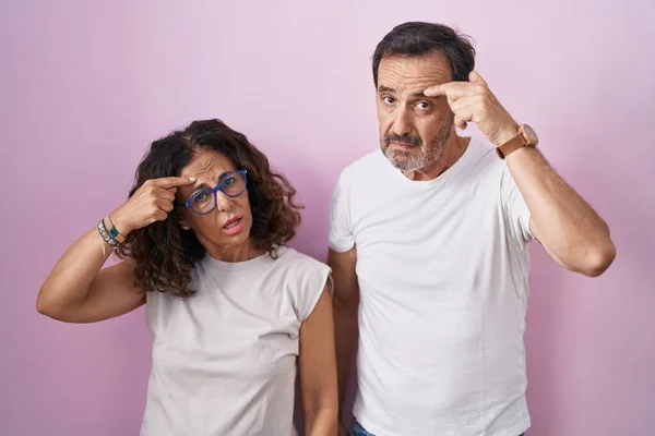 Middle Age Hispanic Couple Together Pink Background Pointing Unhappy Pimple — Stock Photo, Image