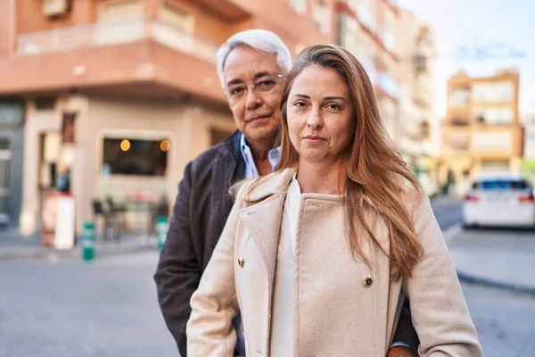 中年男性と女性のカップルは ストリートでリラックスした表情と一緒に立って — ストック写真