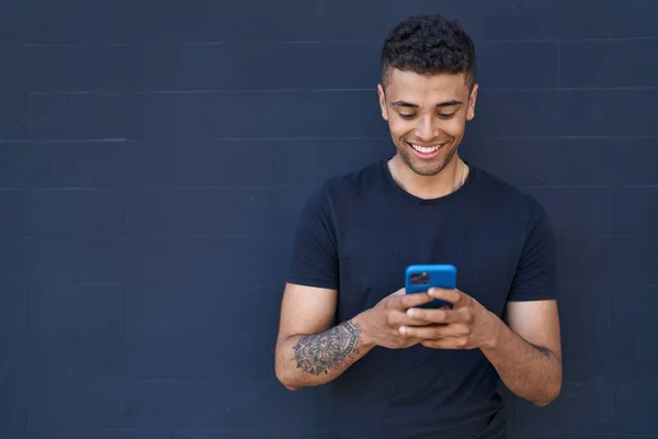 Hombre Afroamericano Sonriendo Confiado Usando Teléfono Inteligente Sobre Fondo Negro —  Fotos de Stock