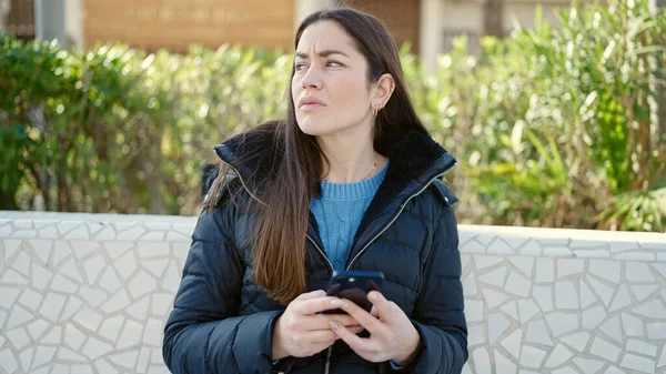 Młoda Kaukaska Kobieta Pomocą Smartfona Patrząc Zdenerwowany Park — Zdjęcie stockowe