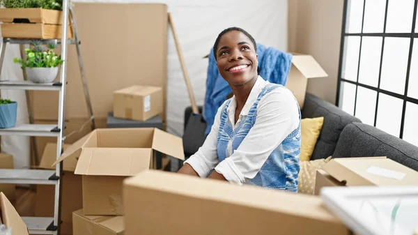 Afro Amerikaanse Vrouw Glimlachen Zelfverzekerd Zitten Bank Nieuw Huis — Stockfoto
