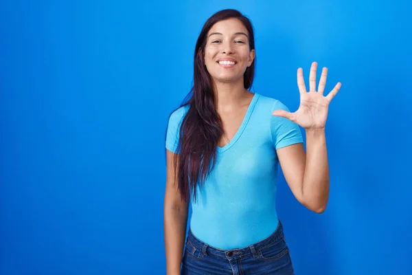 Mladá Hispánka Stojící Nad Modrým Pozadím Ukazující Ukazující Prsty Číslo — Stock fotografie