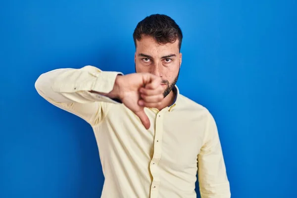 Mavi Arka Planda Duran Yakışıklı Spanyol Adam Mutsuz Kızgın Görünüyor — Stok fotoğraf