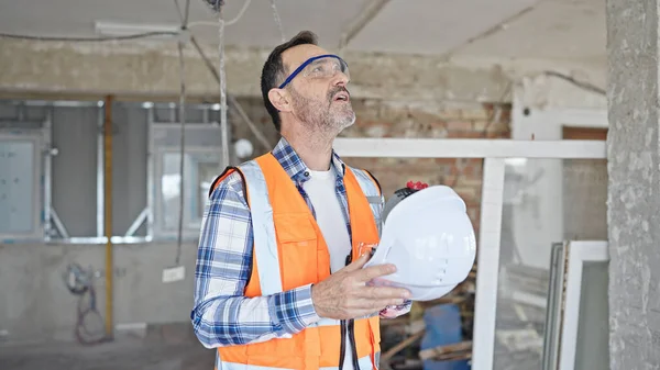 建筑工地的中年男子建筑工人已经厌倦了用硬礼帽作为手工风扇 — 图库照片