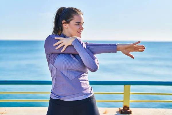 Ung Vacker Latinamerikansk Kvinna Bär Sportkläder Stretching Arm Vid Havet — Stockfoto