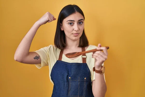 Hispanisches Mädchen Isst Gesunden Kochlöffel Starke Person Zeigt Armmuskeln Selbstbewusst — Stockfoto