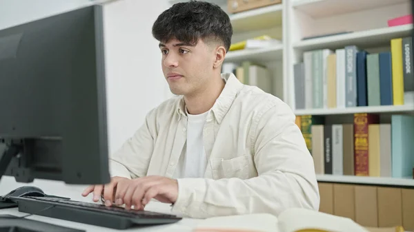 図書館大学でコンピュータを勉強している若いヒスパニック系の学生 — ストック写真