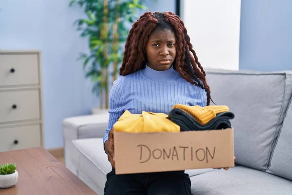 慈善のための寄付箱を持っているアフリカの女性は懐疑的で緊張し 問題のために動揺を眉をひそめています 否定的な人 — ストック写真
